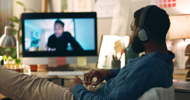 istock Computer, web vlog and man watching movie with snacks and food in home office. Relax, internet and African male person with film subscription app and tech with headphones listening to online video 2057402744