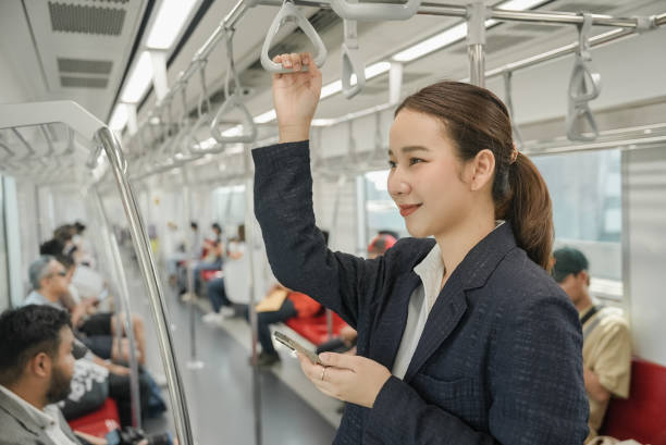 istock Happy young woman passenger smile and using smartphone in subway train station 2057420182