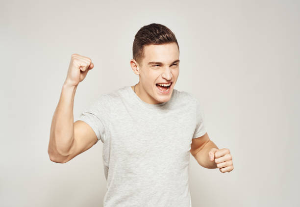 istock A man in a white t-shirt gestures with his hands emotions studio light background 2057446188