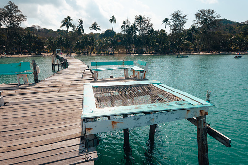 Wooden pier by the beach and clear blue water on Koh Kood