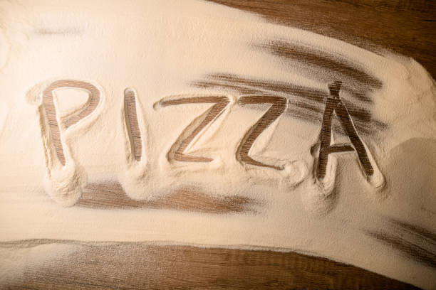 istock Word on white sifted flour on a wooden table before preparing pizza 2057489595