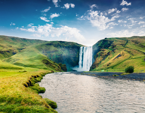 Colorful summer scene with pure water of Skogafoss Waterfall. Sunny morning on the Skoga river, south of Iceland, Europe. Artistic style post processed photo.