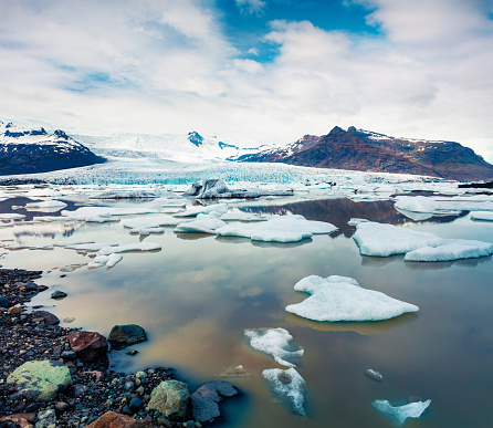 Floating ice box on the Fjallsarlon glacial lagoon. Frosty summer morning in Vatnajokull National Park, southeast Iceland, Europe. Artistic style post processed photo.