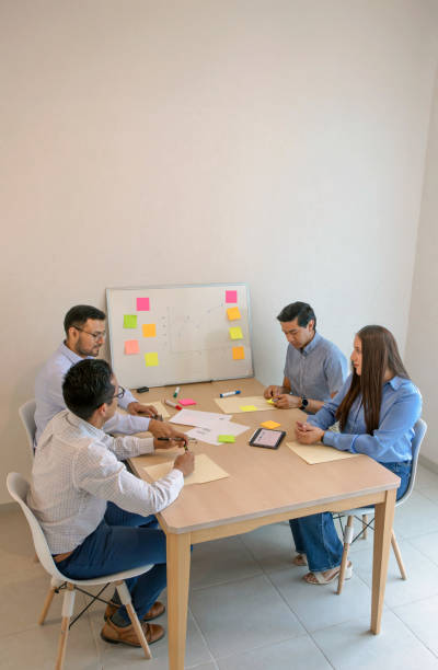istock A group of people sitting around a table with sticky notes 2057503920