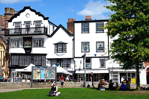 Front view of the Mols and other building in Cathedral Close tourists enjoying the sunshine, Exeter, Devon, UK, Europe.