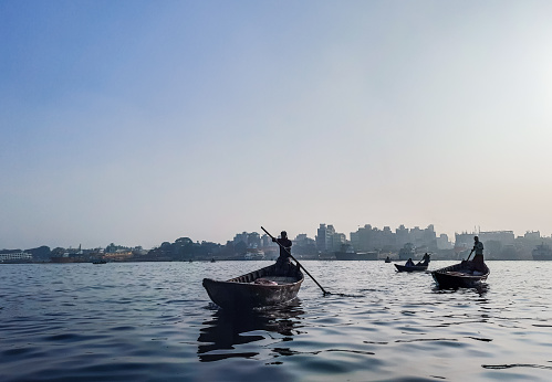 Sadarghat river view landscape, Transporting local people by small boats across the river, Commuter ferryboat in the monsoon, Boat ride in the Buriganga river.