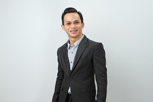 Happy confident asian indonesian business man in suit on isolated background