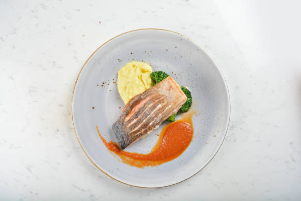 istock pan fried bbq fresh cod, salmon, grouper fish fillet in chef sauce with potato, corn and vegetables in plate on white table restaurant luxury hotel western cafe halal menu 2057547042
