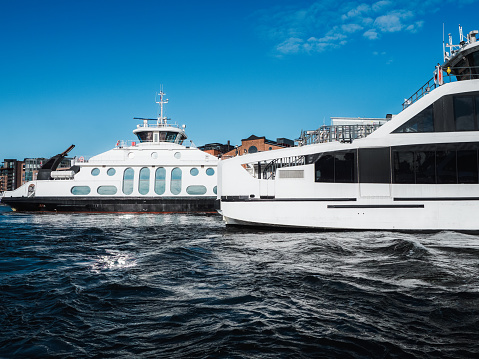 Modern ferry cruising in Oslo fjord and arriving to a city quayside, Oslo urban dock, Norway