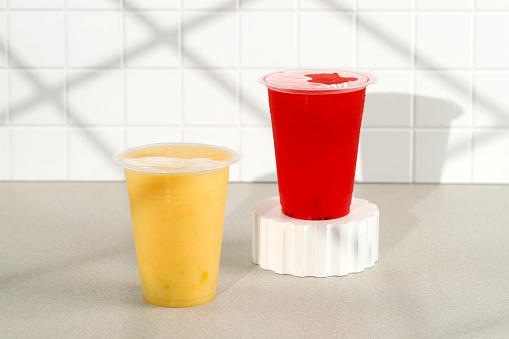 Red and Yellow Juice on Sealed Plastic Cup. On the Go Juice, Street Food Market Product