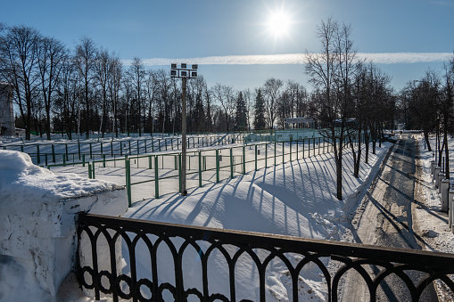 Tennis courts covered with snow in a city park in winter.