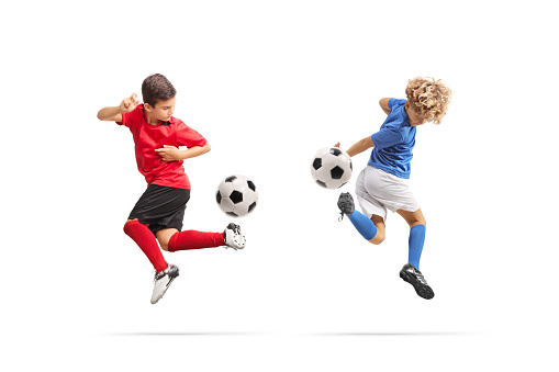 Boys kicking a football with back heel isolated on white background