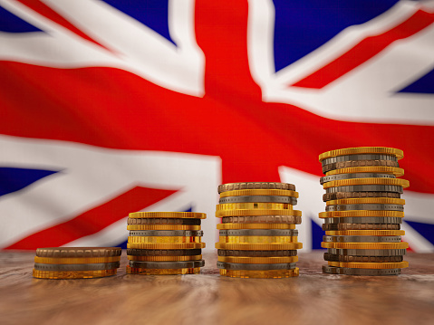 Stack of Coins Rising with British Flag in the Background. Finance and Economy Concept. 3D Render
