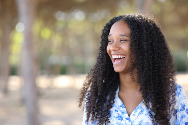 Joyful black woman laughing loud in a park