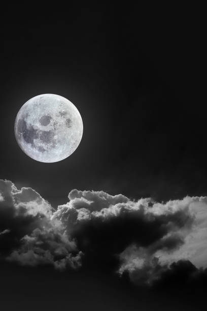 istock Dramatic atmosphere of bright and beautiful midnight full moon with clouds on peaceful dark night summer clear sky. Moon image furnished by NASA. 2057612151