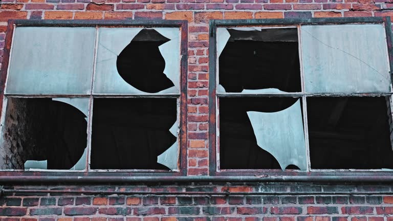 Old Neglected Red Brick Industrial Factory Building with Shattered Glass Windows