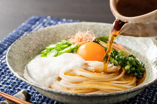 Bukkake udon is boiled udon noodles topped with grated yam, ginger, green onion, wakame, and dried bonito flakes.
