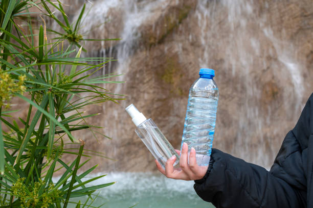 Cologne and water bottle in human hand