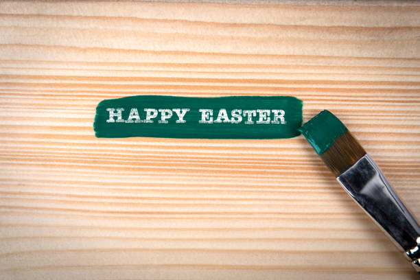 Happy Easter. Green paint and brush on wood texture background.