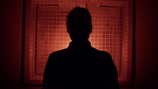 Silhouette of a person against a red illuminated grid