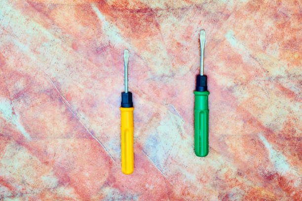 a tool with a flattened, cross-shaped, or star-shaped tip that fits into the head of a screw to turn it
