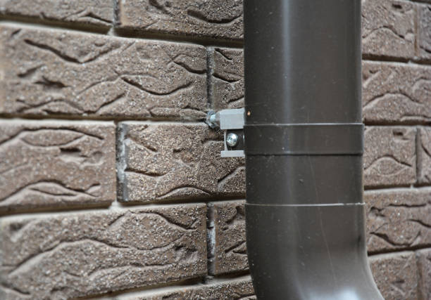 istock Close up on house rain gutter downspout pipe anchor bolt holder on the brick wall. 2057719328