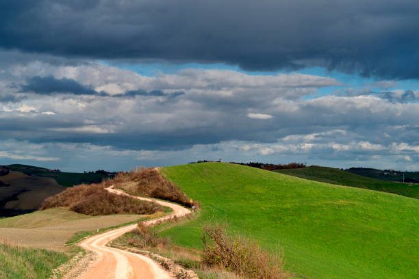 istock Country road upper the hill against cloudy sky 2057723032