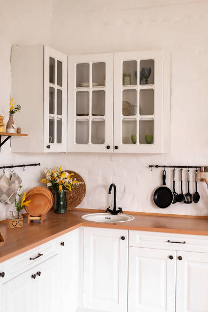 istock Wooden counter with white sink and utensils near light wall in kitchen 2057724081