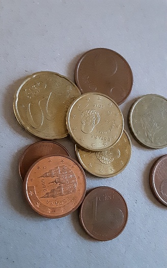 Euro coins on gray speckled surface.