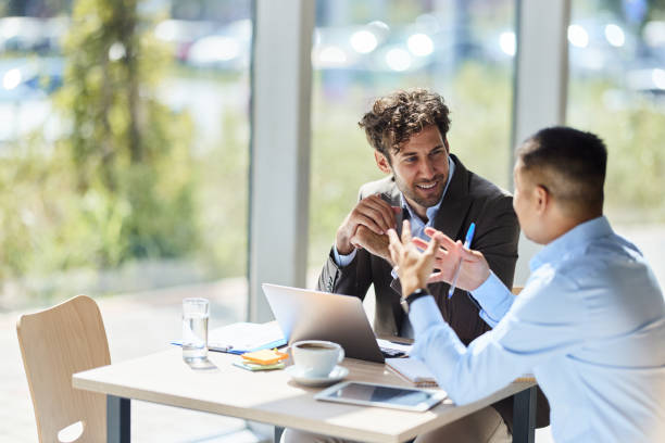 happy male entrepreneurs communicating while working in the office. - två människor bildbanksfoton och bilder