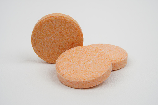 Closeup of chewable vitamin c tablet concept background