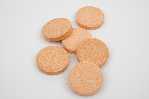 Chewable vitamin c tablet as a body supplement concept background