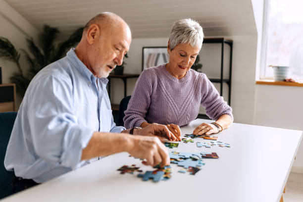 istock Senior couple doing jigsaw puzzle at home together 2057743314