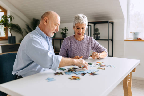istock Senior couple doing jigsaw puzzle at home together 2057743831