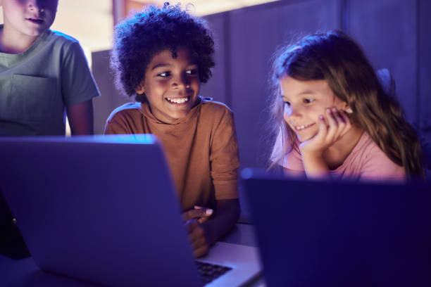 happy little kids surfing the internet on a computer. - computer lab child internet development photos et images de collection