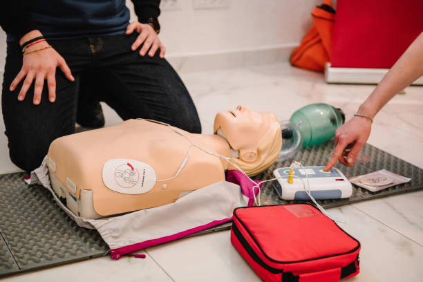 istock Use an automatic defibrillator in conducting basic cardiopulmonary resuscitation of victim. Automated external defibrillator device, AED with training dummy mannequin. Demonstrating chest compressions 2057756914
