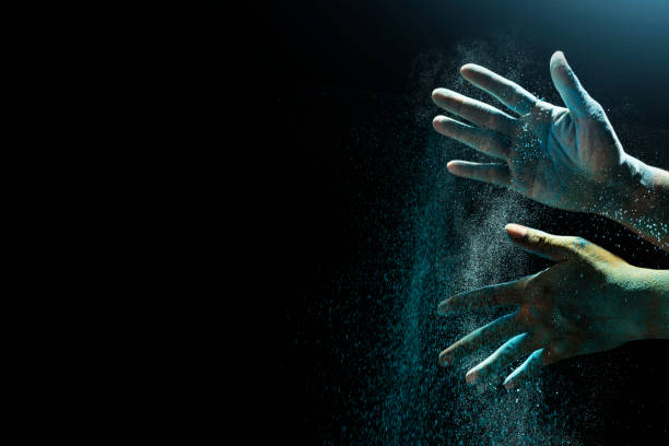Human hand with colorful Holi powder on a black background. Holi festival concept