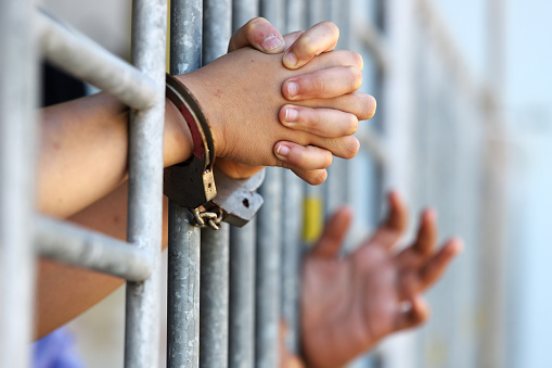 hands of prisoner in jail as background