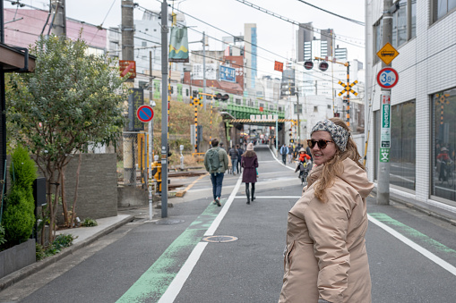 A young woman looking back while walking down an urban street in Tokyo