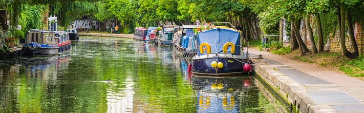 Colourful narrow boats moored along the the Regent’s Canal in the heart of Central London, UK.