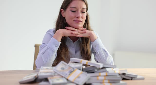 Woman enjoys pile of scattered banknotes in office