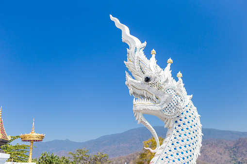 White naga head sculpture with space on clear blue sky background, White Naga sculpture at the temple on top of the mountain in northern Thailand