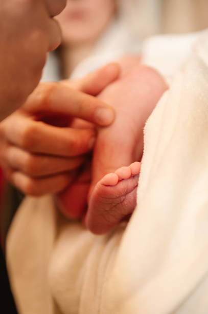 babyfüße. beine des säuglings. niedliches kleines schlafen. mutter hält einen säugling auf dem arm. closeup. winzige nackte füße eines neugeborenen mädchens oder jungen, eingewickelt in eine weiche und kuschelige decke. seitenansicht. - furniture barefoot little boys family stock-fotos und bilder