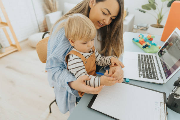 istock Busy mother working at home while taking care of her son 2057812051