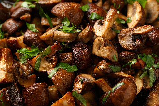 Delicious fried mushrooms with herbs and parsley in plate
