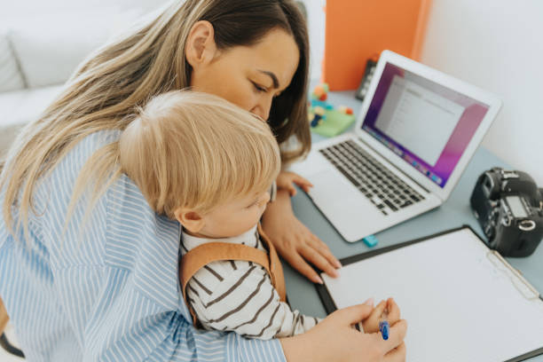 istock Busy mother working at home while taking care of her son 2057823665