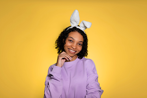 Copy space easter banner with happy smiling sfrican american girl in eater bunny ears. Studio shot. Place for text. High quality photo