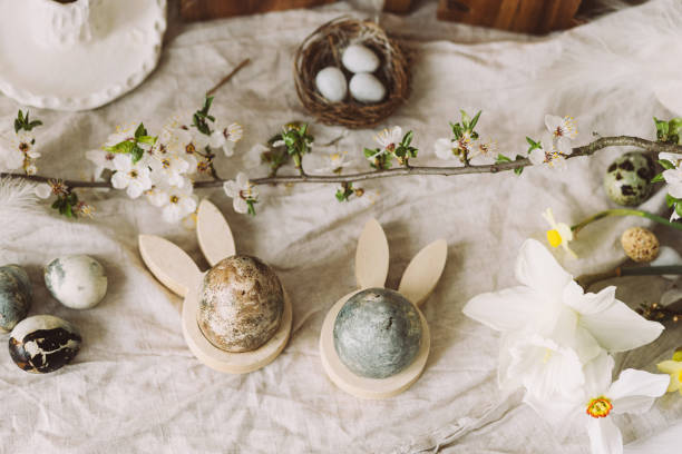istock Happy Easter! Stylish easter eggs, bunnies and cherry blossom flat lay on rustic table. Modern natural dyed marble eggs and spring flowers. Easter decor in countryside home 2057872949