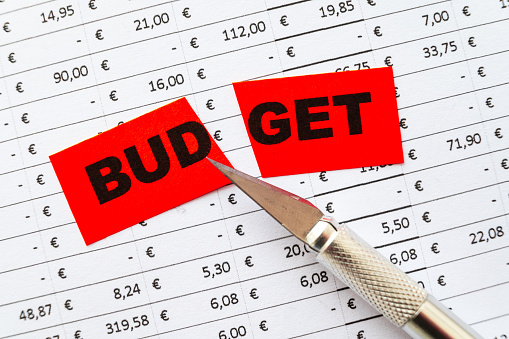 Table with budget, expenses, revenues and ticket with Budegt text cut in two. Budget cut.