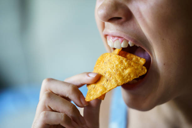 istock Crop anonymous girl with mouth wide open eating spicy nacho chips 2057889518